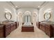 A stunning main bathroom with dual vanities, a central soaking tub, marble columns, and tiled walk-in showers at 21321 Harborside Blvd, Port Charlotte, FL 33952