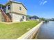 Backyard with grass, a canal seawall, and staircase to a second floor porch at 24313 Pirate Harbor Blvd, Punta Gorda, FL 33955