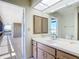 Bathroom with a wide mirror, a vanity with storage, and an open doorway to a porch at 24313 Pirate Harbor Blvd, Punta Gorda, FL 33955