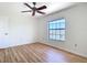 Bedroom features a ceiling fan, wood floor, and a large window with natural light at 24313 Pirate Harbor Blvd, Punta Gorda, FL 33955