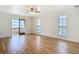 Bright bedroom with wood flooring, a ceiling fan, and sliding glass doors to a balcony at 24313 Pirate Harbor Blvd, Punta Gorda, FL 33955