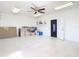 Bright garage featuring white walls, tile flooring, a ceiling fan, and convenient access to the house at 24313 Pirate Harbor Blvd, Punta Gorda, FL 33955