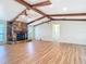 Spacious living room featuring a stone fireplace, exposed beams, and wood flooring at 24313 Pirate Harbor Blvd, Punta Gorda, FL 33955