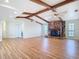 Bright living room with exposed beams, a stone fireplace, and hardwood floors at 24313 Pirate Harbor Blvd, Punta Gorda, FL 33955