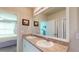 Bright bathroom featuring double sinks, a large mirror, and convenient access to an adjoining bedroom at 7168 W Lenox Cir, Punta Gorda, FL 33950