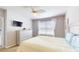 Well-lit bedroom featuring a ceiling fan, window with blinds, TV, and minimalist decor at 7168 W Lenox Cir, Punta Gorda, FL 33950