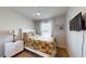 Cozy bedroom featuring a ceiling fan, TV, and a comfortable bed with tropical-themed bedding at 7168 W Lenox Cir, Punta Gorda, FL 33950