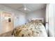 Comfortable bedroom with a ceiling fan, tropical bedding, and a glimpse into the kitchen at 7168 W Lenox Cir, Punta Gorda, FL 33950
