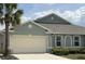 Home exterior with a two-car garage and landscaped with a beautiful palm tree at 7168 W Lenox Cir, Punta Gorda, FL 33950