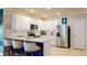 Modern kitchen with stainless steel appliances, white cabinets, a breakfast bar with seating, and tile flooring at 7168 W Lenox Cir, Punta Gorda, FL 33950