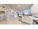Spacious kitchen featuring white cabinets, stainless steel appliances, and a view into the living and dining areas at 7168 W Lenox Cir, Punta Gorda, FL 33950