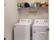 Functional laundry room equipped with a washer, dryer, and shelving for storage at 7168 W Lenox Cir, Punta Gorda, FL 33950