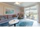 Cozy living room with a comfortable sofa, a coffee table, and a view of the screened-in patio through sliding glass doors at 7168 W Lenox Cir, Punta Gorda, FL 33950