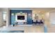 Open concept living room with a blue accent wall, tile flooring, modern entertainment center, and kitchen island at 7168 W Lenox Cir, Punta Gorda, FL 33950