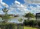 Scenic view of a tranquil pond with a fountain, lush greenery, and nearby houses at 7168 W Lenox Cir, Punta Gorda, FL 33950