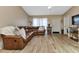 Living room with a brown leather sectional sofa and wood-look tile floors at 3300 Loveland Blvd # 1301, Punta Gorda, FL 33980
