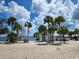 Scenic beach view with palm trees, picnic area, and calm water at 1286 Hillcrest Nw Ave, Port Charlotte, FL 33948