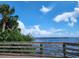 Serene waterfront view with a pier in the distance, under a partly cloudy sky at 1286 Hillcrest Nw Ave, Port Charlotte, FL 33948