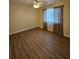 Bright bedroom with wood-look flooring, ceiling fan, and window curtains at 1286 Hillcrest Nw Ave, Port Charlotte, FL 33948