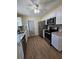 Modern kitchen with granite counters, stainless steel appliances, and wood-look floors at 1286 Hillcrest Nw Ave, Port Charlotte, FL 33948