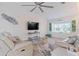 Spacious living room featuring two sofas, a large TV, and a ceiling fan at 5001 Richmond Ter, North Port, FL 34287