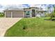 Beautiful house exterior with three car garage and lush landscaping at 14041 Clarissa Ln, Port Charlotte, FL 33981