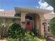 One story home with coral front door and lush landscaping at 7100 Mineola Rd, Englewood, FL 34224