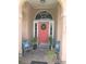 Front entry with coral door, decorative pillows, and tile flooring at 7100 Mineola Rd, Englewood, FL 34224