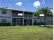Condo building with screened balconies and grassy lawn at 26470 Rampart Blvd # 123, Punta Gorda, FL 33983