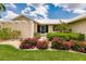 Landscaped front yard with flowering bushes and a metal roof at 3621 Whippoorwill Blvd, Punta Gorda, FL 33950