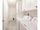 Bright laundry room with white cabinets and tile floor at 3621 Whippoorwill Blvd, Punta Gorda, FL 33950