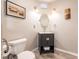 Small, updated half bathroom with a dark vanity and oval mirror at 3621 Whippoorwill Blvd, Punta Gorda, FL 33950