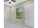 Bedroom with marble floors, single window, white door, and ceiling fan at 212 Fairway Rd, Rotonda West, FL 33947