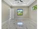 Bright bedroom featuring marble floors, tray ceiling, recessed lights, and an open door at 212 Fairway Rd, Rotonda West, FL 33947