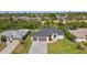 Beautifully landscaped home features a paved driveway, attached two-car garage, and well-maintained green lawn at 212 Fairway Rd, Rotonda West, FL 33947