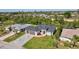 Beautifully landscaped home features a paved driveway, attached two-car garage, and well-maintained green lawn at 212 Fairway Rd, Rotonda West, FL 33947