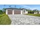 New home featuring two-car garage, stone driveway, and well-manicured front yard at 212 Fairway Rd, Rotonda West, FL 33947