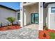 Inviting front entrance with modern double doors, lush landscaping and brick paver walkway at 212 Fairway Rd, Rotonda West, FL 33947