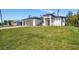 Well-manicured front yard of a modern home with a three-car garage at 212 Fairway Rd, Rotonda West, FL 33947