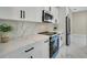 Close up of updated kitchen with stainless steel appliances and white marble countertops and cabinets at 212 Fairway Rd, Rotonda West, FL 33947