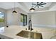 Open-concept kitchen with marble countertops, a stainless steel sink, and modern pendant lighting at 212 Fairway Rd, Rotonda West, FL 33947