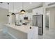 Gourmet kitchen featuring white cabinets, stainless steel appliances, and a large island with a sink at 212 Fairway Rd, Rotonda West, FL 33947