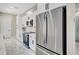 Modern kitchen featuring stainless steel refrigerator, white cabinets, and sleek black hardware at 212 Fairway Rd, Rotonda West, FL 33947