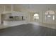 A naturally lit living space flows into the kitchen with light countertops and new flooring at 515 Allworthy St, Port Charlotte, FL 33954