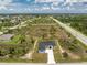 An aerial view showcasing a house and surrounding empty land at 9526 Rosebud Cir, Port Charlotte, FL 33981