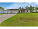 Two-car garage, light-colored exterior, and manicured lawn at 16195 Maya Cir, Punta Gorda, FL 33955