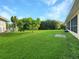 Large grassy backyard with mature landscaping and home at 695 Coronado Dr, Punta Gorda, FL 33950