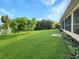 Spacious backyard with lush grass, mature trees, and partial view of home at 695 Coronado Dr, Punta Gorda, FL 33950