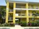 Two-story yellow building with balconies and landscaping at 2140 Heron Lake Dr # 204, Punta Gorda, FL 33983
