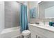 Bathroom features a bathtub, shower, white vanity and teal accents at 13198 Gotham Ave, Port Charlotte, FL 33953